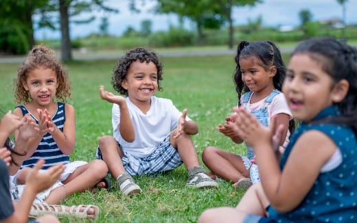 a group of children sitting on the grass
