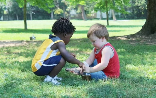 two children playing in the grass