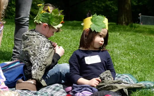 a couple of girls sitting on the grass