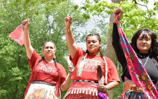a group of women holding up red and white flags