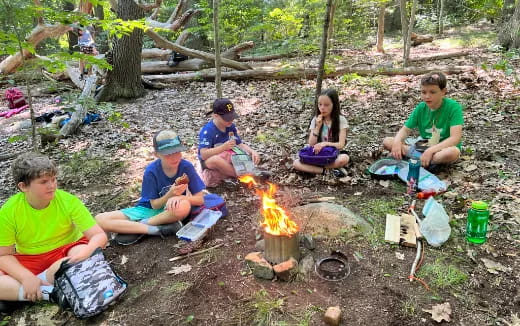 a group of people sitting in the woods