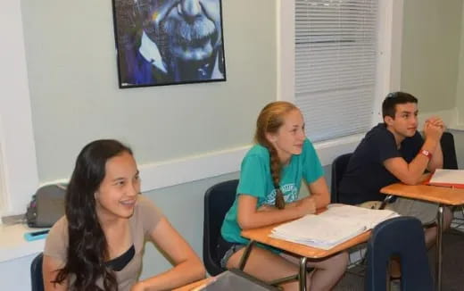 a group of people sitting at desks in a room