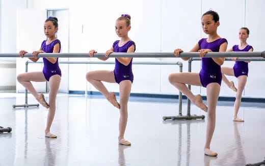 a group of women in leotards in a gym