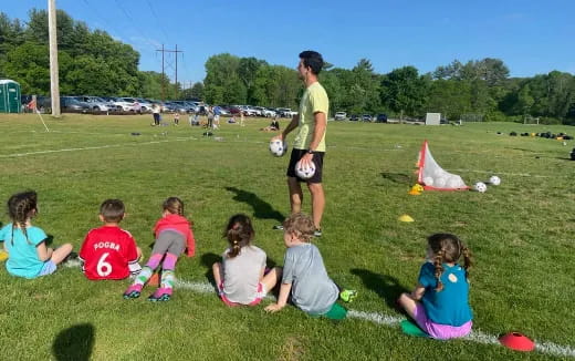 a group of kids sitting on the grass