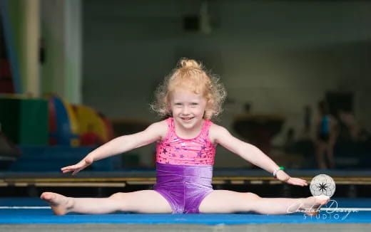 a girl in a leotard on a mat