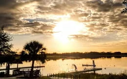 a body of water with trees and a dock by it