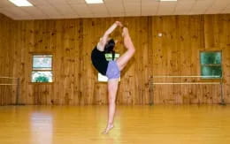 a person doing a handstand in a room with wood walls