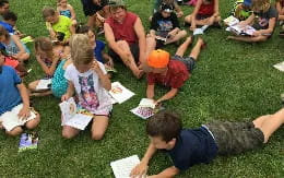 a group of people sitting on the grass