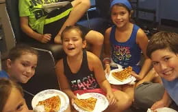 a group of kids eating pizza