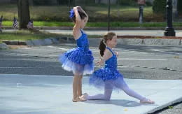 two girls wearing blue dresses and dancing