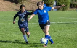 girls playing football on a field