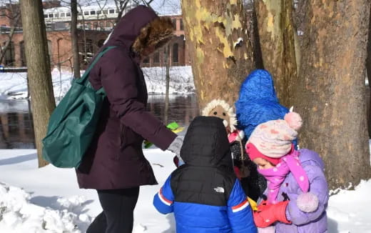 a woman walking with a group of children in the snow