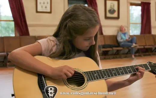 a girl playing a guitar