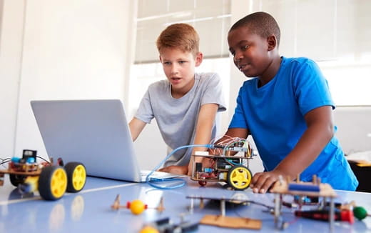 a couple of boys working on a computer