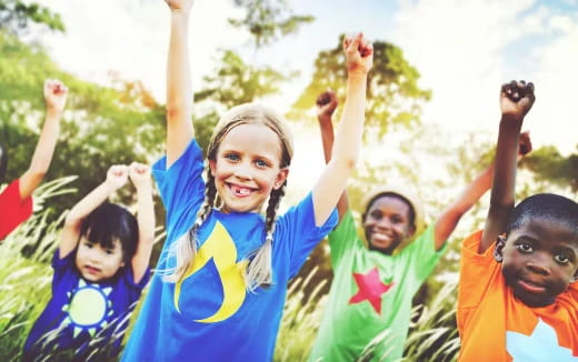 a group of children raising their hands
