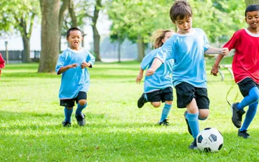 kids chasing a football ball