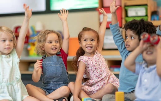 a group of children raising their hands