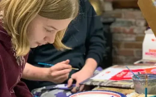 a woman painting on a table