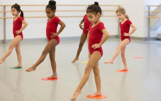 a group of girls in red leotards on a rink
