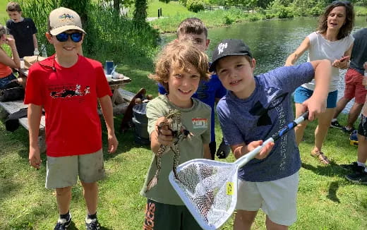 a group of kids stand around a baseball bat