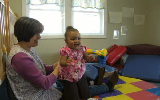 a person and a child sitting on a bed