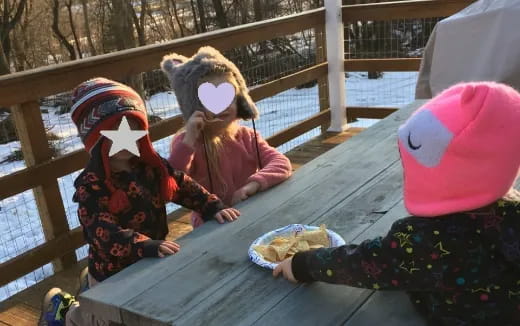 a group of people in clothing sitting on a bench