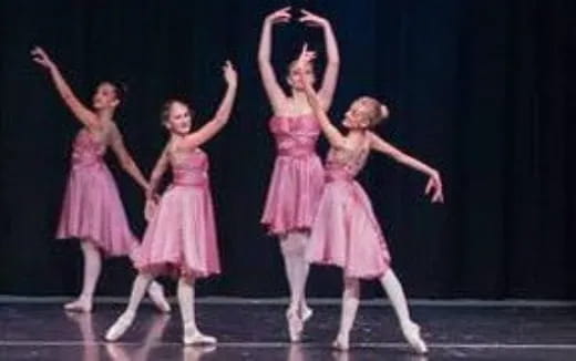 a group of girls dancing on a stage