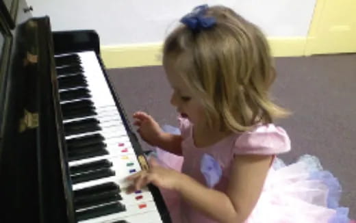 a little girl playing a piano