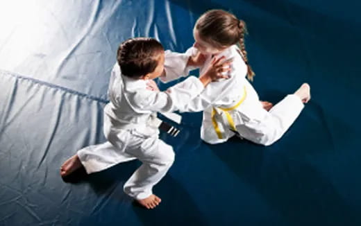 a couple of children in karate uniforms