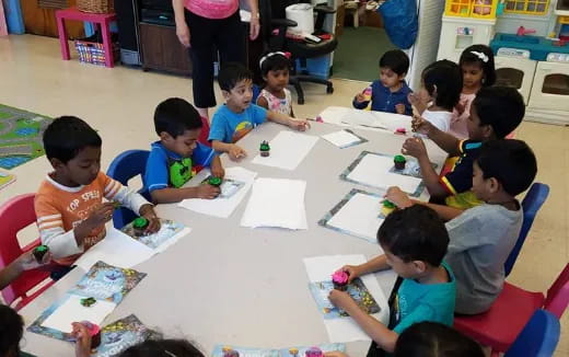 a group of children sitting around a table