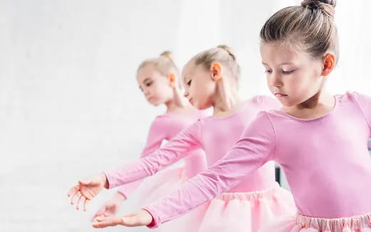 a group of children in pink dresses