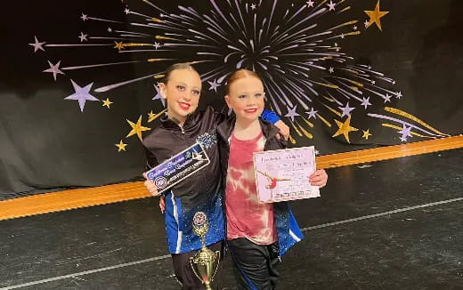 two girls holding a trophy