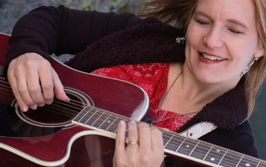 a woman playing a guitar