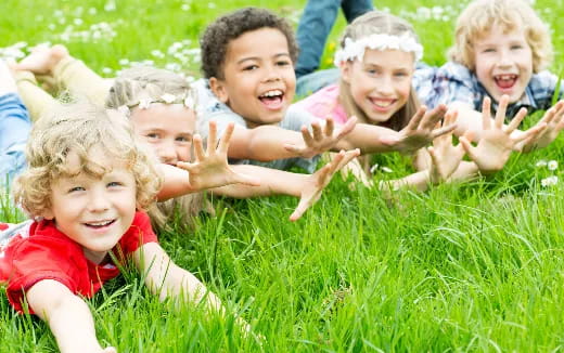 a group of children lying in the grass