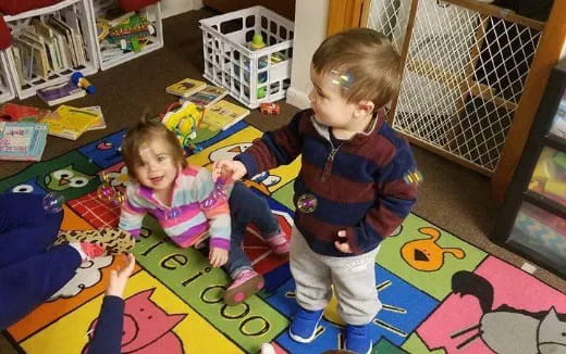 a couple of children playing on a colorful floor