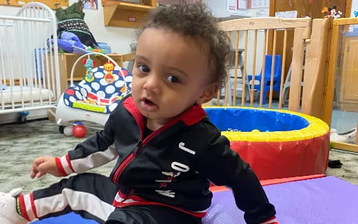 a baby sitting in a playroom