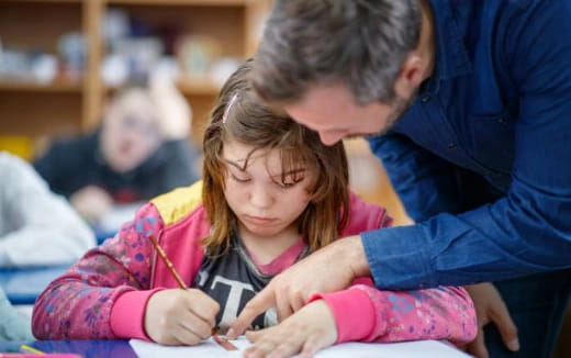a young girl writing on a book