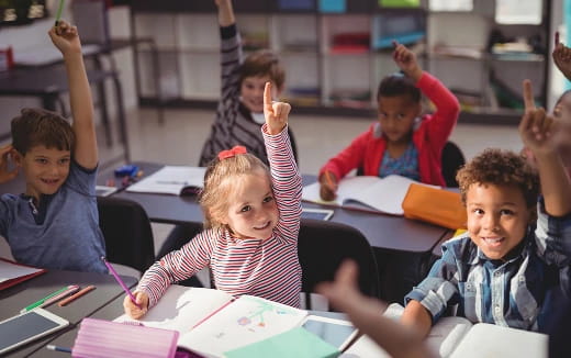 a group of children raising their hands