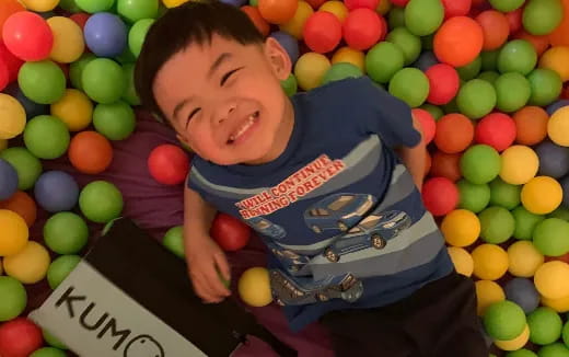 a boy lying in a ball pit