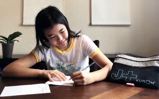 a woman writing on a piece of paper