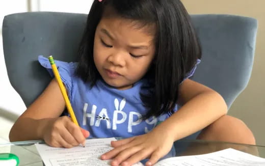 a girl writing on a piece of paper