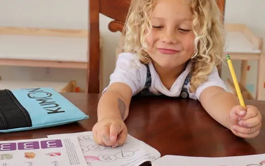 a child writing on a piece of paper