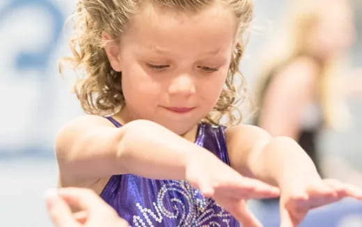 a baby girl with her hands on her chest