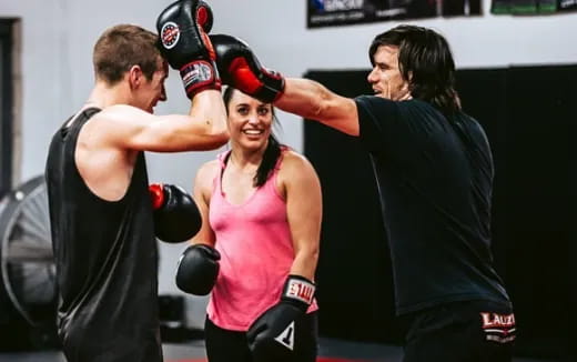 a woman in a boxing ring with a man in the back