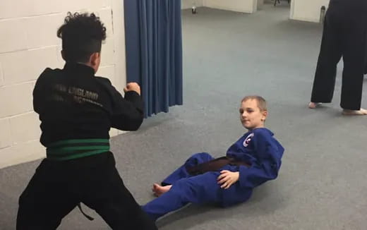 a person kneeling next to a boy lying on the ground