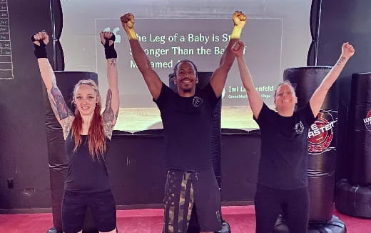 a group of people lifting their hands up