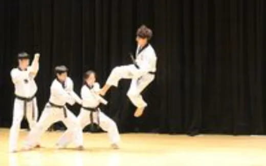 a group of people in white karate uniforms