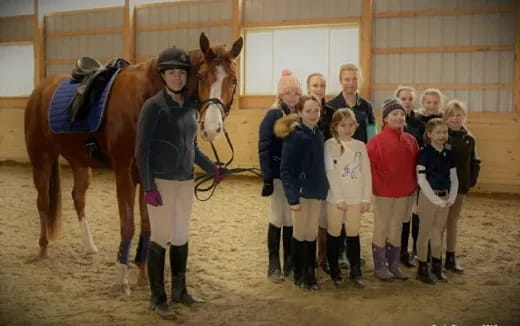 a group of people posing with a horse