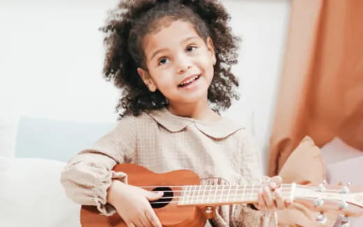 a young girl playing a guitar