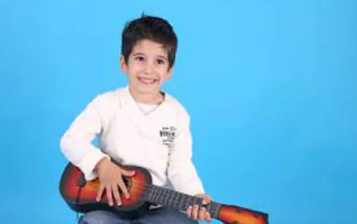 a boy holding a guitar